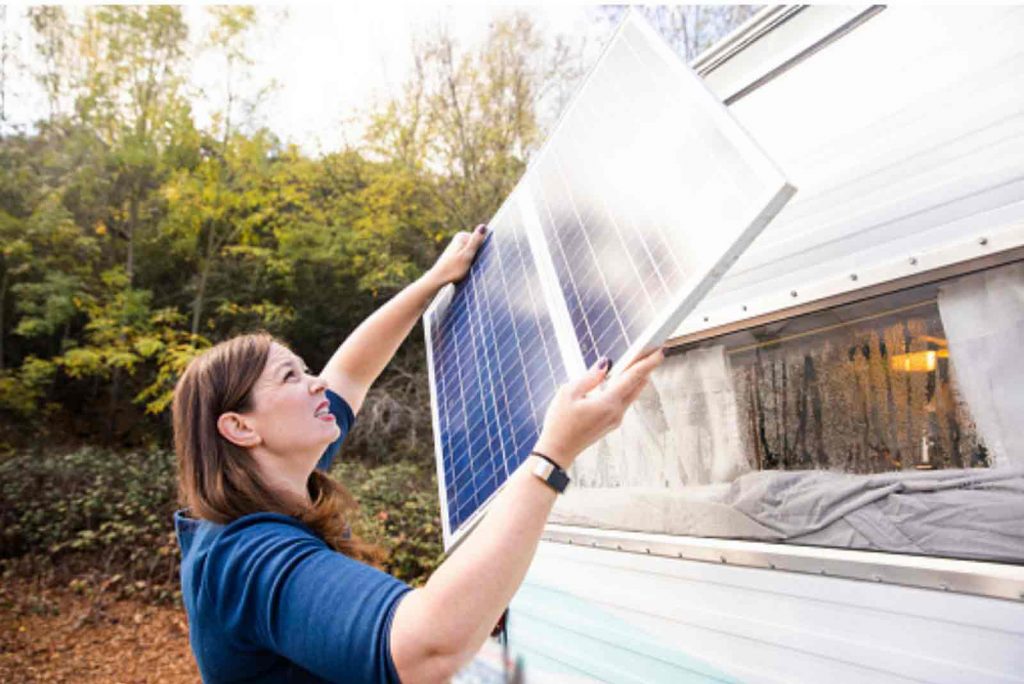 Woman installing Solar Panel on RV