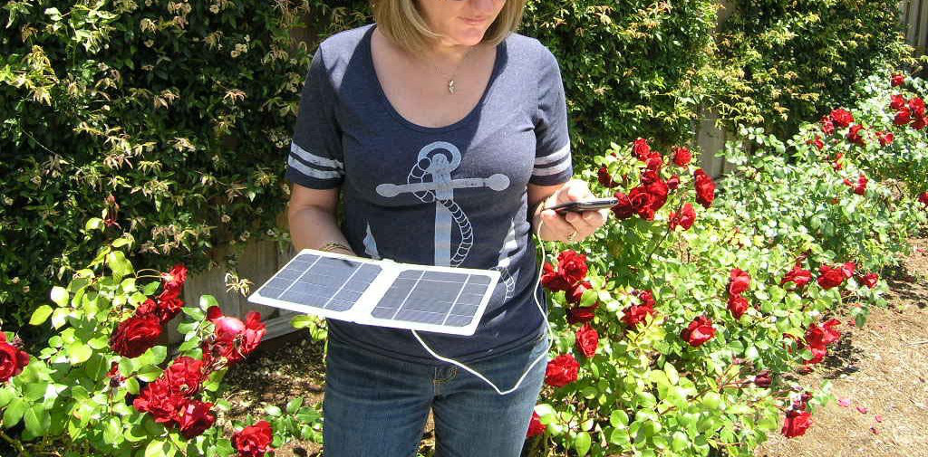 Woman holding Solar panel charger for phone